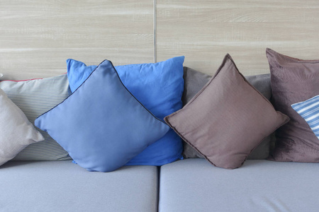 蓝色和棕色枕头躺在木墙在背景光蓝沙发上