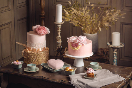 用乳香和玫瑰金在古色古香的经典室内装饰的豪华婚礼表与一个漂亮的粉红色蛋糕