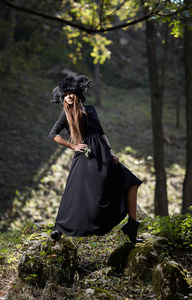 在黑色的连衣裙和黑色的帽子，走在神秘女模特