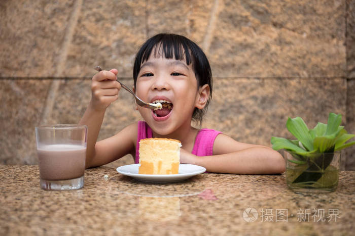 亚洲中国小女孩吃美味的蛋糕
