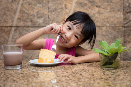 亚洲中国小女孩吃美味的蛋糕