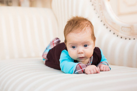 男婴，红色的头发，蓝眼睛的特写肖像。刚出生的孩子 lyling 在沙发上