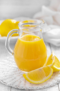在玻璃水罐和新鲜的水果，在白色的木制背景 维他命饮料或鸡尾酒柠檬汁