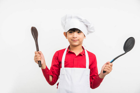 印度孩子厨师生涯中，在厨师制服在白色背景下的印度可爱男孩