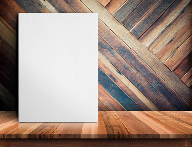 张空白的纸海报在对角木板木制的桌子上