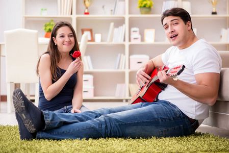 浪漫的双在地板上玩吉他