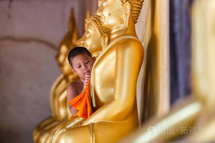 小沙弥擦洗佛像在泰国寺