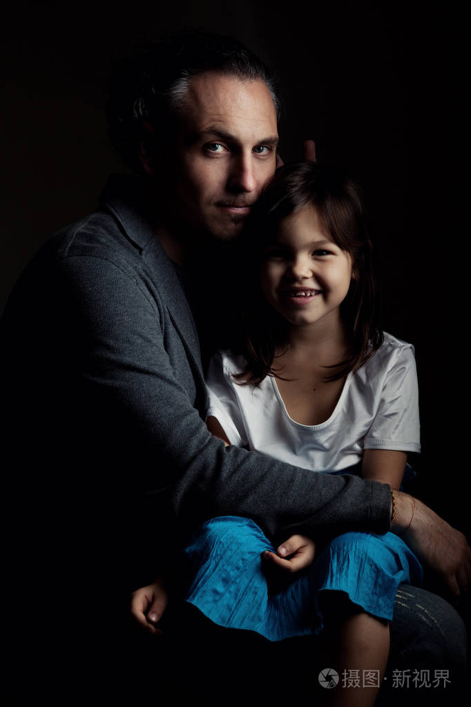 父亲在拥抱微笑着女儿牵
