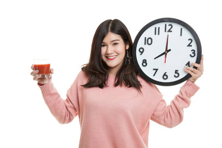 年轻的亚裔女子和番茄汁和时钟