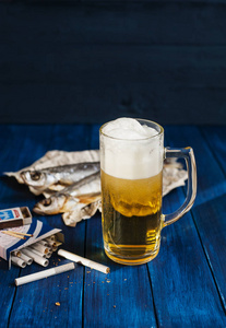 烟草店在一杯啤酒腌鱼和桌上的香烟照片