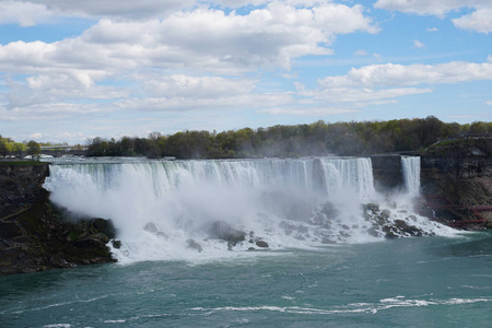 来自加拿大安大略省的明亮的春天的尼亚加拉大瀑布瀑布与云彩和蓝天