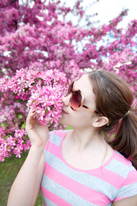 美丽的春天的时候。年轻十几岁的女孩，嗅到的樱桃树 f