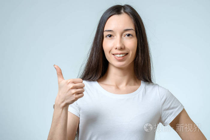 微笑快乐年轻的黑发女人,显示竖起大拇指的手势