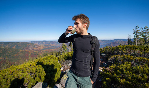 年轻健康男性的徒步旅行者喝茶的肖像