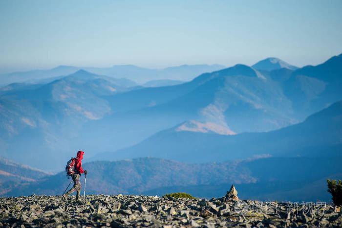 走在这座山的岩石顶部的男性 backpaker