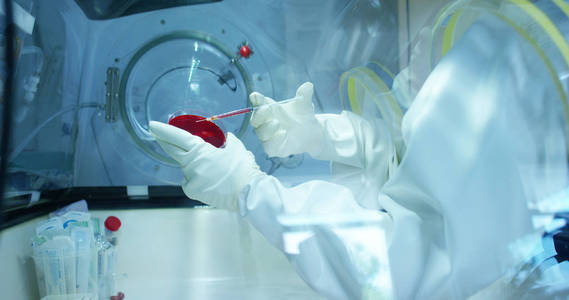 医生分析液体病毒细胞在专业实验室使用合格的设备和戴上眼镜以保护眼睛和照顾的实验室眼镜