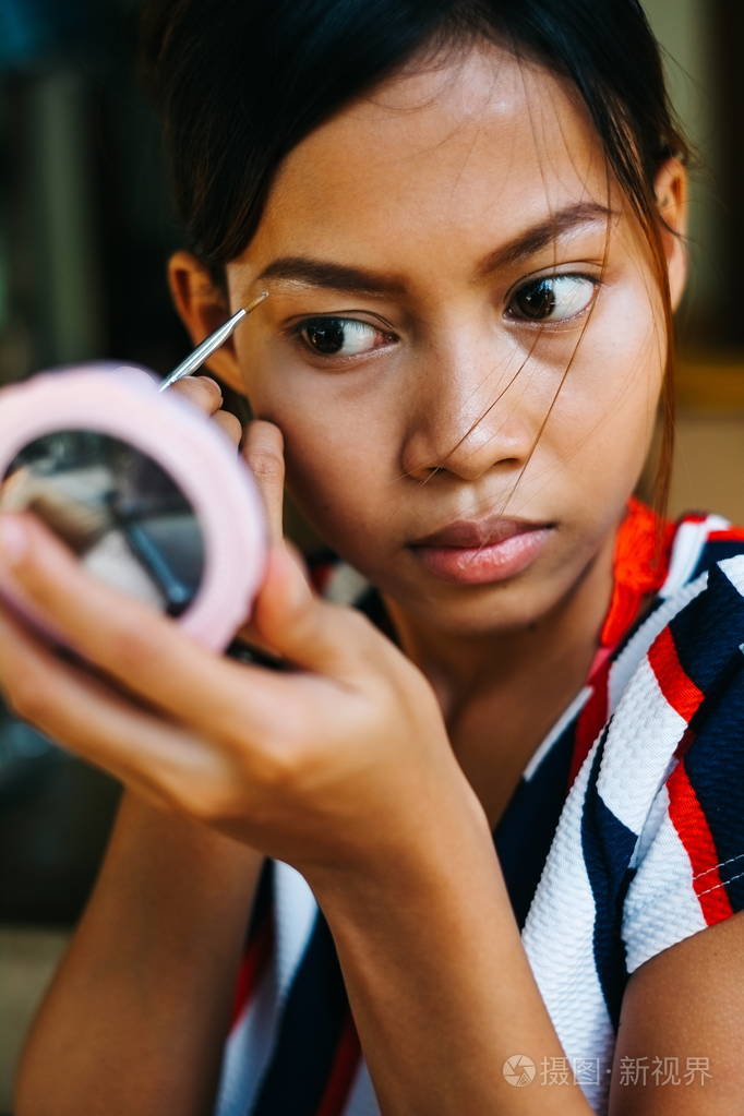 年轻漂亮的女孩化妆.着色眉毛眉毛内衬的女孩