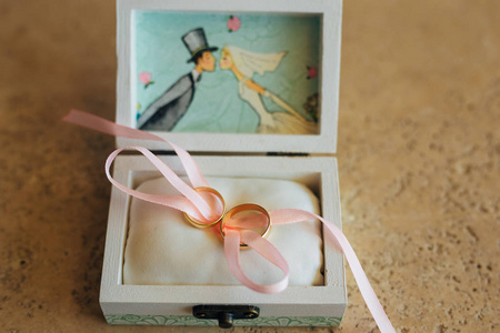 在一个盒子里新婚夫妇的结婚戒指。黄金订婚戒指