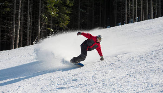 男性的滑雪板从山上滑下