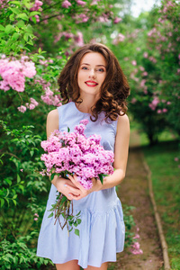 年轻的女孩站在公园背景用束鲜花