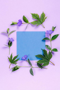 方形花相框与紫罗兰色背景上的蓝色床单