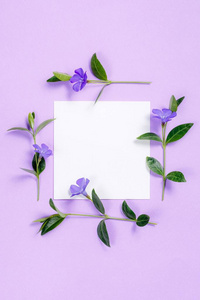 方形花相框与白色的床单上紫色背景