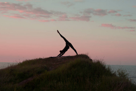 适合女人做瑜伽伸展运动户外在美丽的高山景观 女性的海和日出或日落背景培训asans 岩石上 女人的瑜伽体式的剪影照片 正版商用图片0u3mz3 摄图新视界