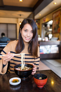 女人一家日本餐厅吃乌冬面