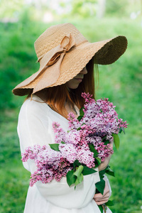 一束春天的花园里开满丁香花的红发女孩