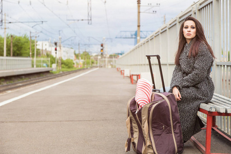 空火车站上一个空的火车站,带了一袋的女孩.等火车照片