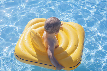 小男孩用游泳池黄色橡胶环