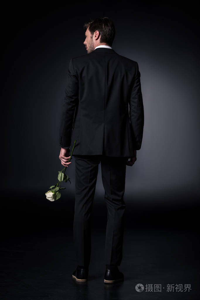 正式的服装,拿着玫瑰的男人