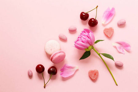 粉红色背景用鲜花和杏仁，甜和妇女