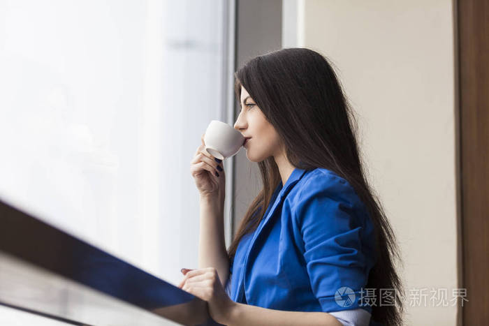 在办公室里喝咖啡的女人