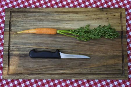 胡萝卜和刀在木板上。极简主义