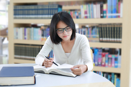 亚洲学生阅读书在图书馆里