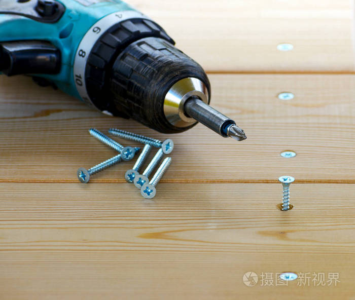 螺钉和电钻在木板上