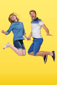 一对年轻夫妇在黄色背景下跳的肖像
