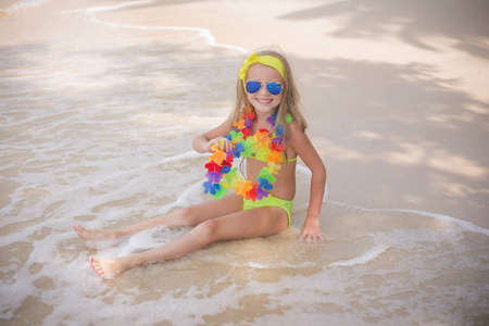 快乐的小女孩在彩色太阳镜游泳在海边沙滩上