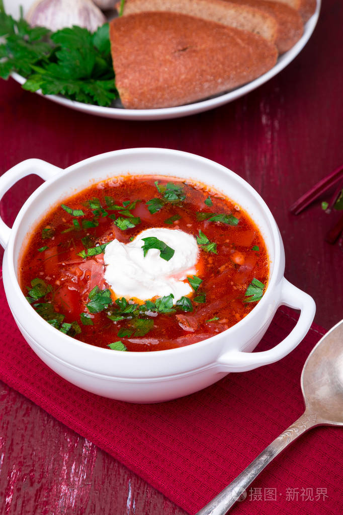 乌克兰的传统罗宋汤.俄罗斯素食红汤红木制背景上的白色碗里.