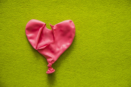 泄了气的粉红色红色气球照片