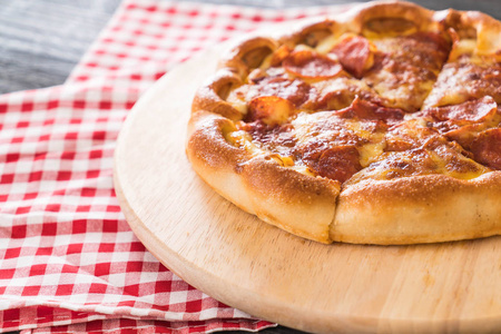 在木板上的自制意大利辣香肠比萨饼。