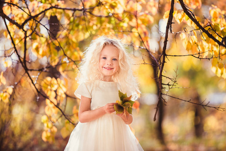 一个小女孩穿白色连衣裙她微笑的人爱他们的背景上