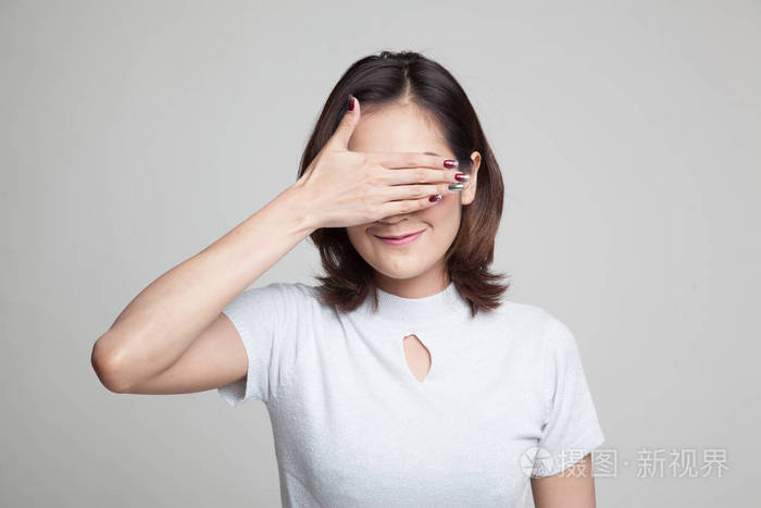 年轻的亚洲女人她闭上眼睛用一只手