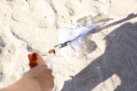 年轻的人清洁海滩地区