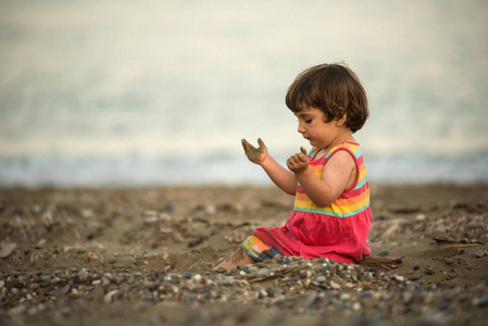 蹒跚学步的婴儿在沙滩上玩