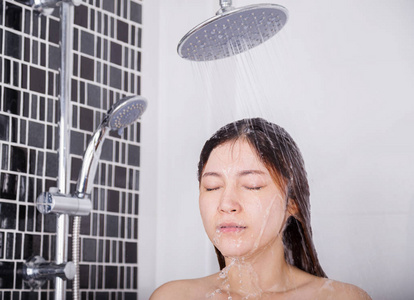 女人由雨淋浴洗她的头发和脸