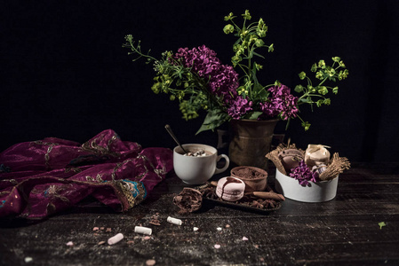 与咖啡和饼干铜编织花瓶里的木桌上的东方样式老的流动紫色透明围巾