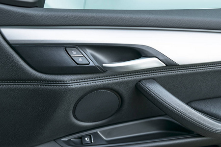 汽车门把手与黑色皮革和开关按钮控制,现代汽车内饰细节豪华现代车内