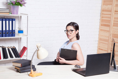 业务女孩坐在电脑前办公纸文件夹中